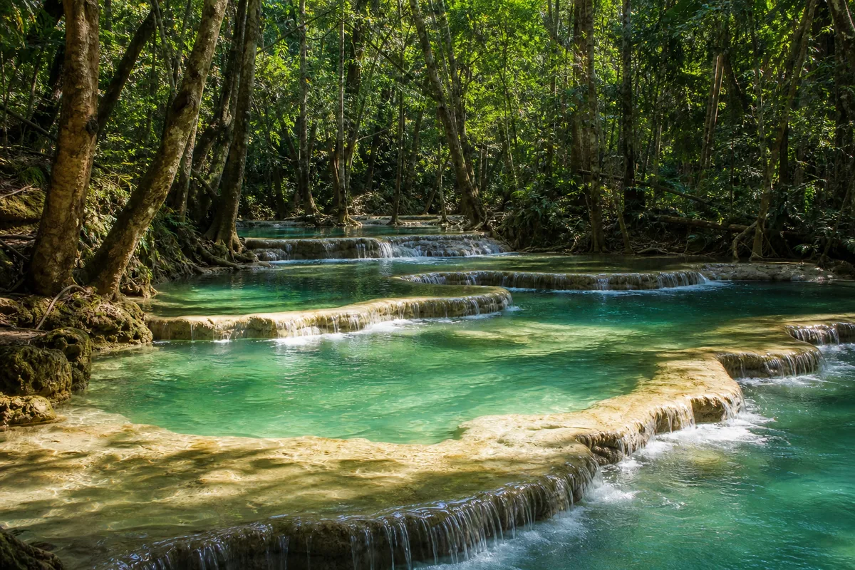エラワン滝のエメラルドグリーンの水をたたえた段状の滝壺と森