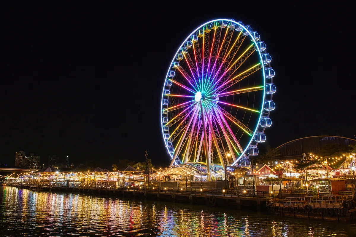夜にライトアップされたアジアティーク・スカイの大観覧車と川沿いの夜景