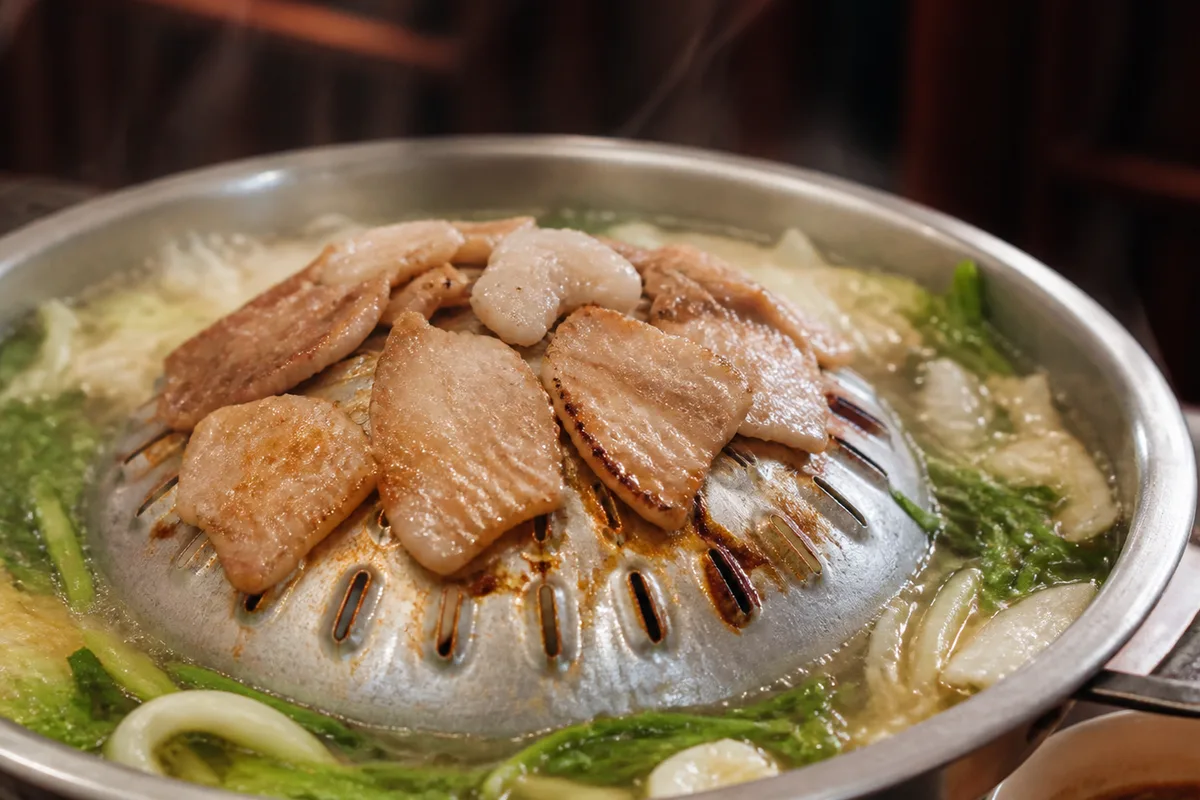 ノンカイチムチュムのムーカタ鍋で肉と野菜を焼いている様子